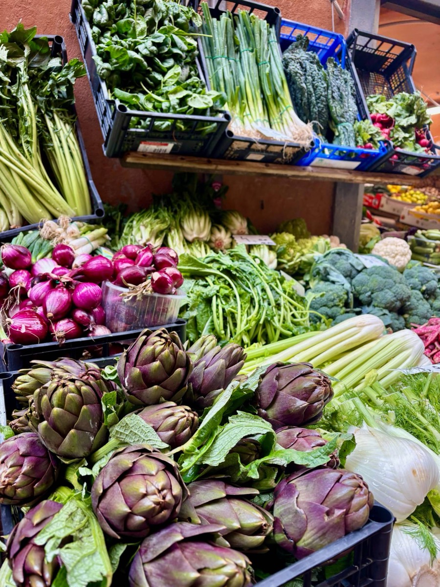 Artichokes, red onions and greens at a market stall in Bologna